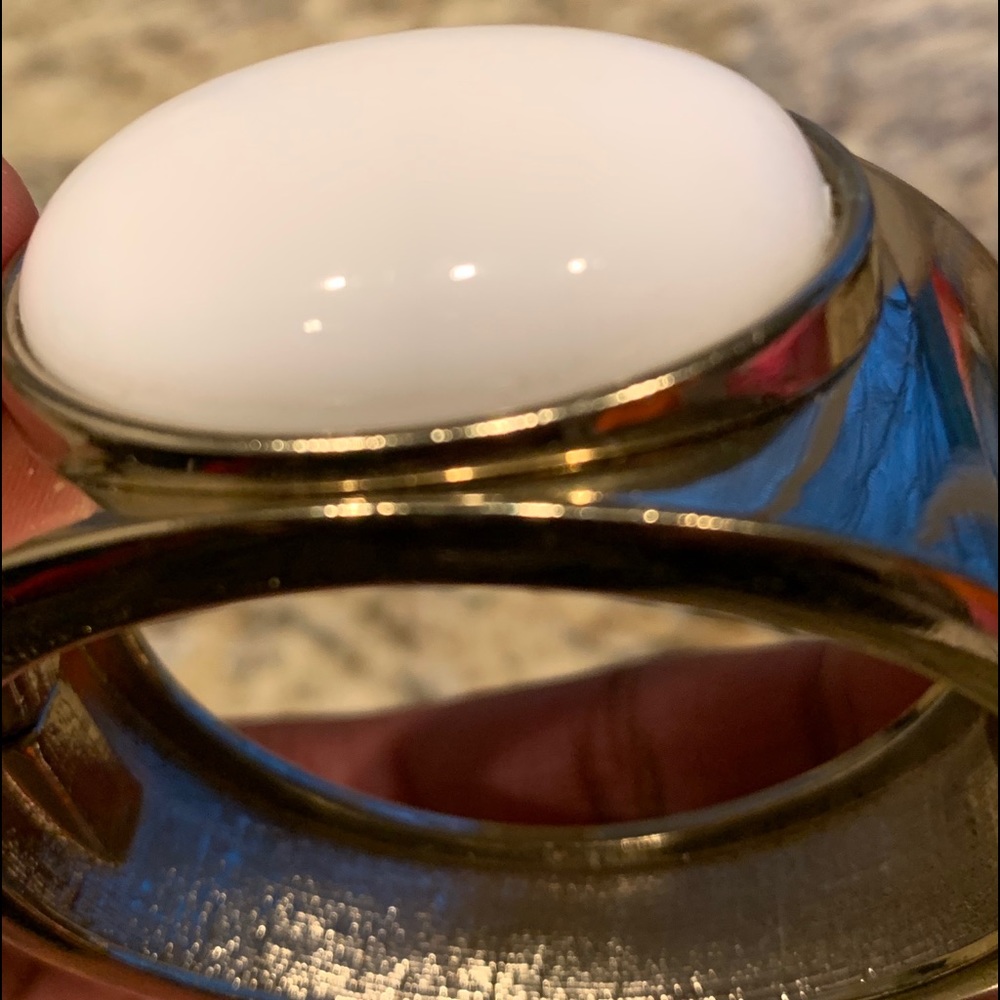 Gold colored bangle with white stone